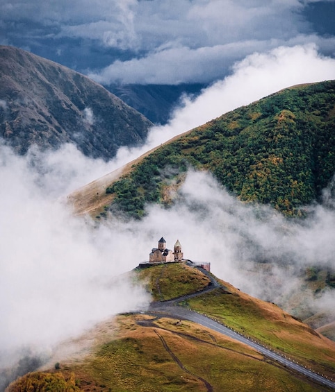 A castle on a hill surrounded by clouds. 5