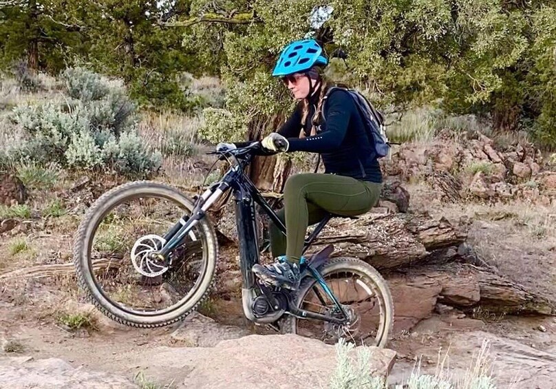 A person riding a mountain bike on a rocky trail surrounded by trees. 2