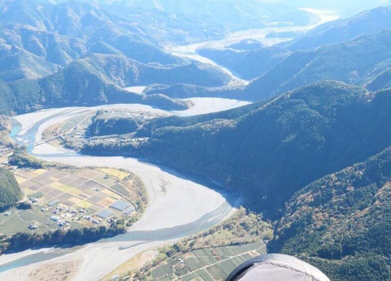 A river winding through a mountainous landscape with agricultural fields. 5