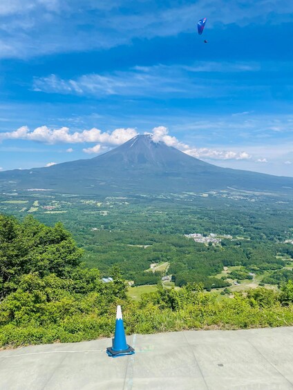 A mountain with a clear sky, a blue cone, and a kite. 3