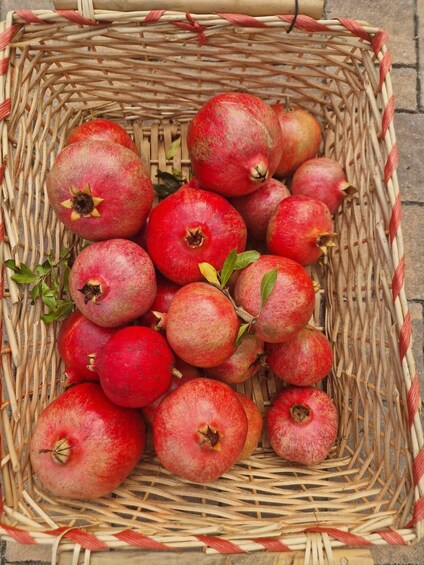 A wicker basket filled with pomegranates. 2