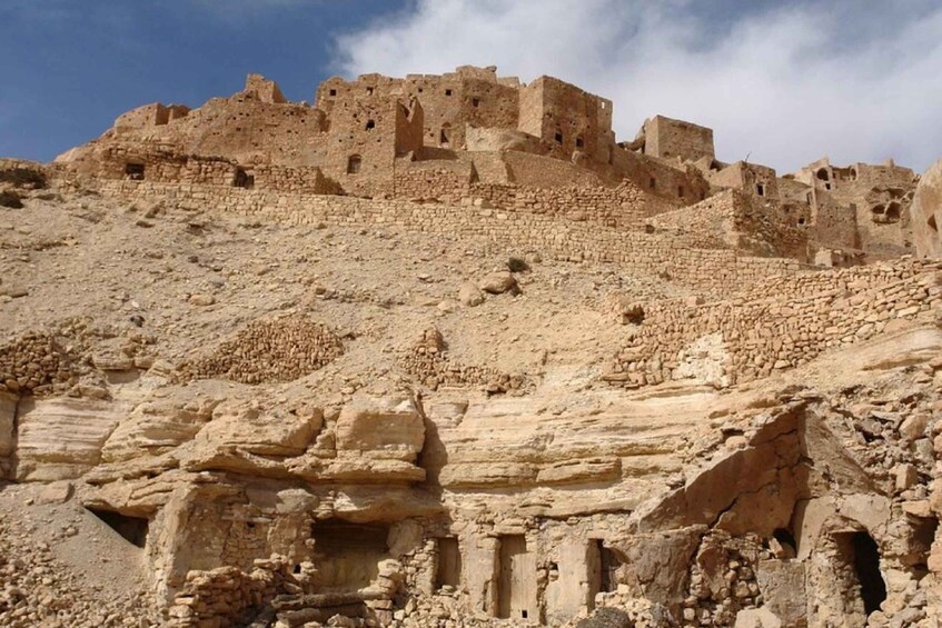 Ancient ruins with stone structures and walls on a hillside. 2