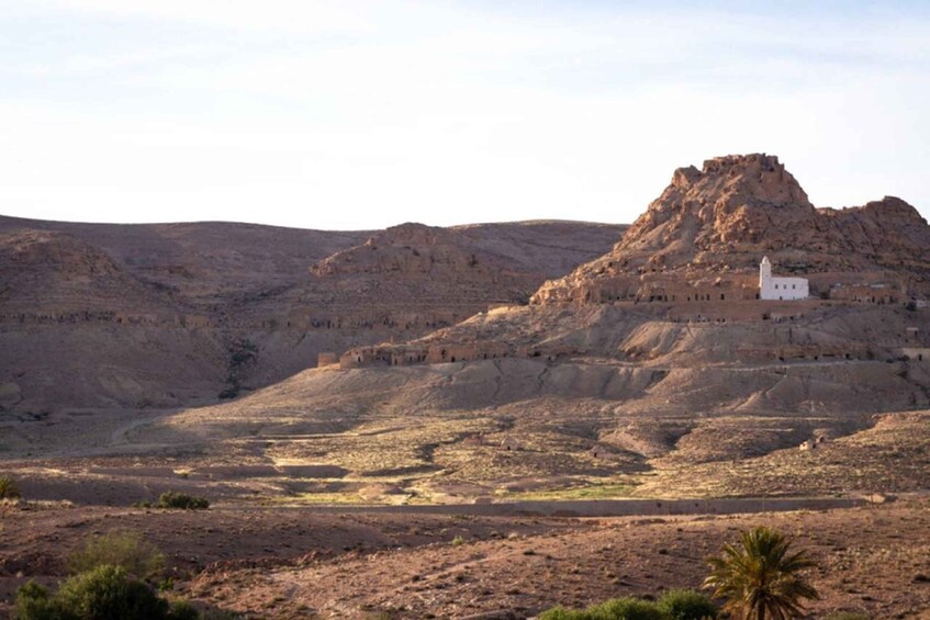 A white church on a hill with a rocky landscape. 3