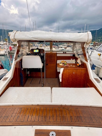 A boat's deck with a steering wheel, control panel, and a table with food and drinks. 5