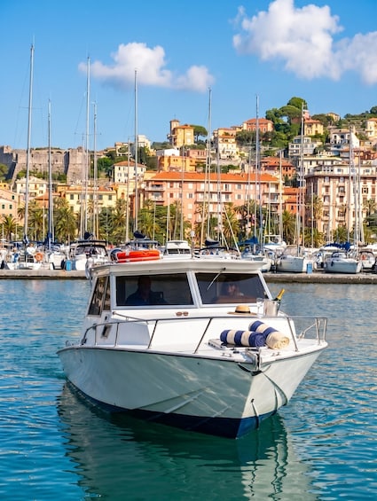 A boat docked in a marina with a backdrop of colorful buildings and a clear sky. 2