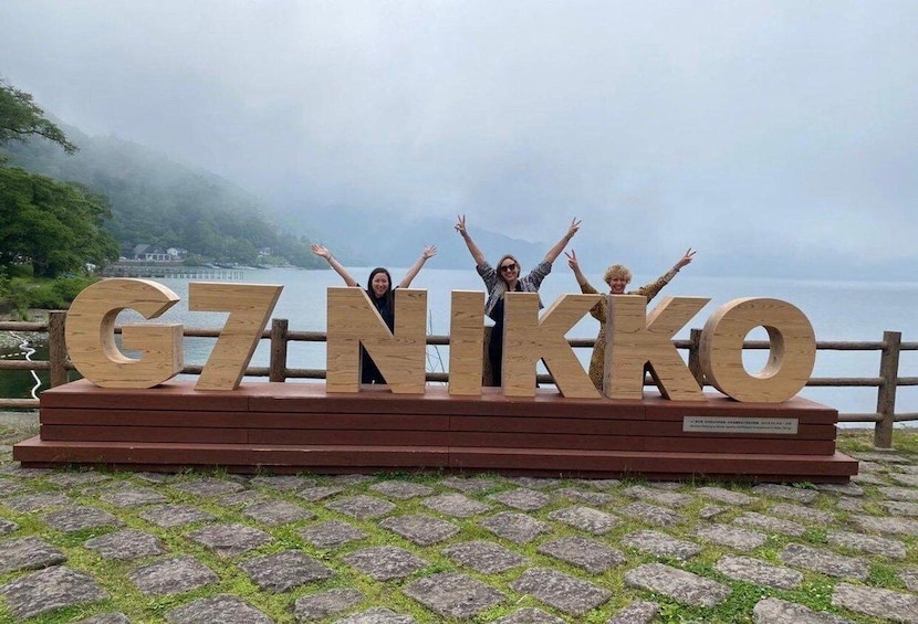 A wooden sign with the letters 'G7NIKKO' and a plaque below it. 2