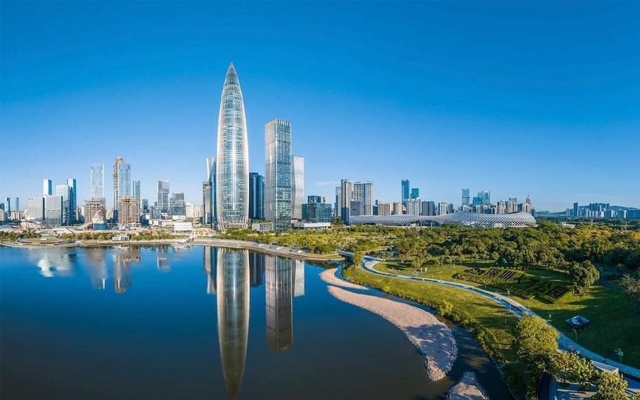 A city skyline with a prominent skyscraper, a river reflecting the buildings, and a park with a pathway. 5