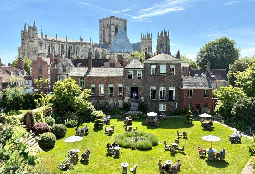 A historic building with a large garden and outdoor seating area. 3