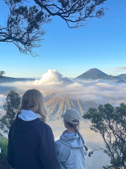 Two people overlooking a mountain with a cloud-covered valley. 5