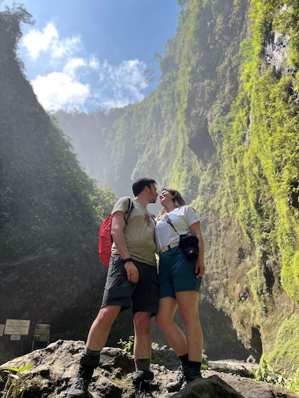 A couple standing on a rocky outcrop with a canyon in the background. 1