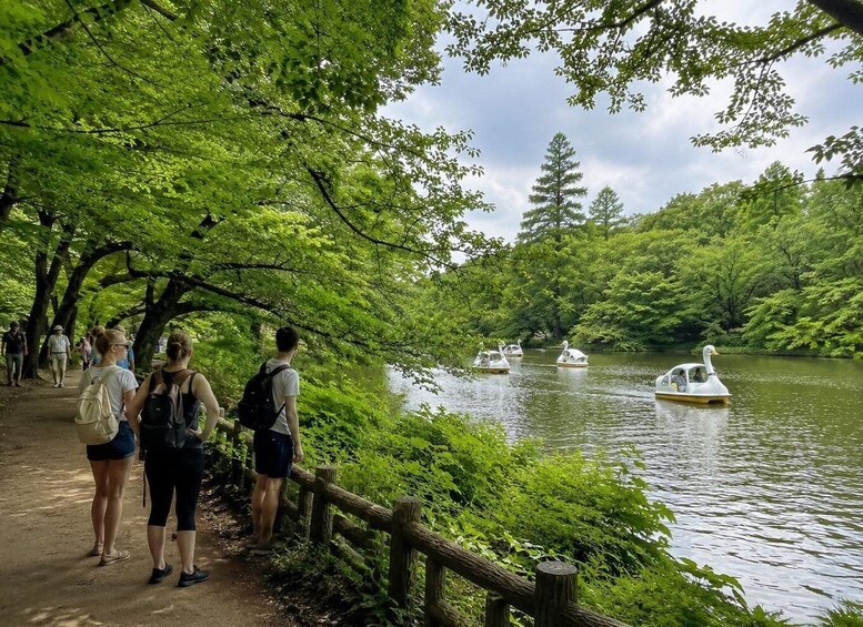 A group of people walking along a path beside a river with boats. 2