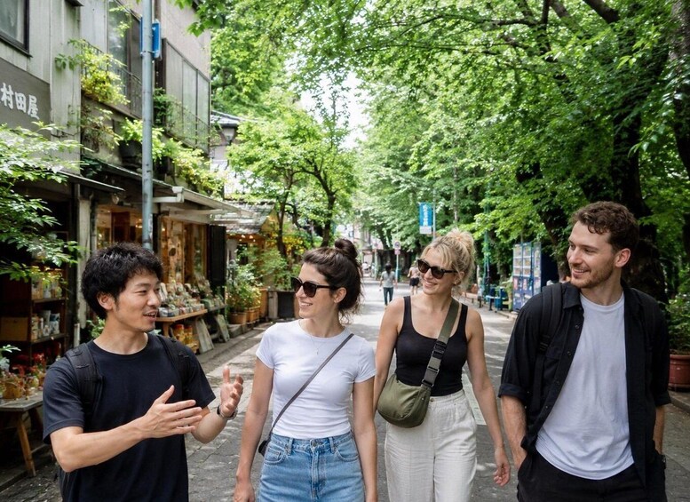 A group of people walking on a tree-lined street with shops on the left. 4