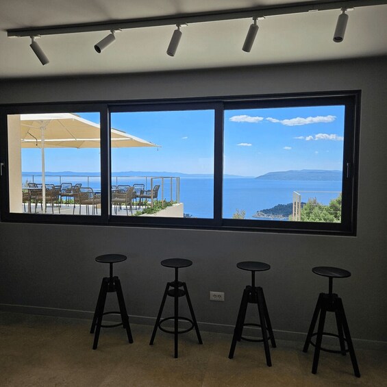 A room with a large window overlooking a coastal view. 3