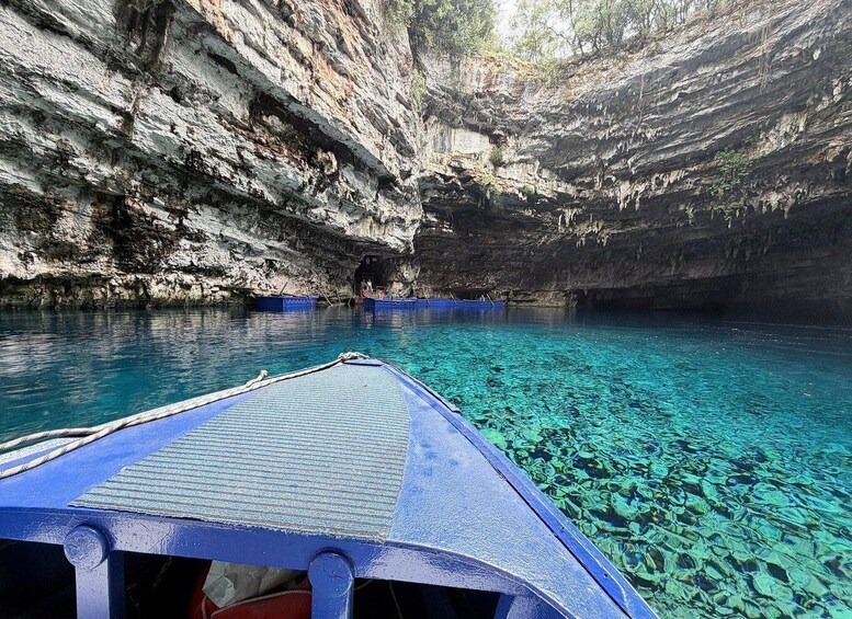 A boat in a clear blue cave pool with rocky walls. 5