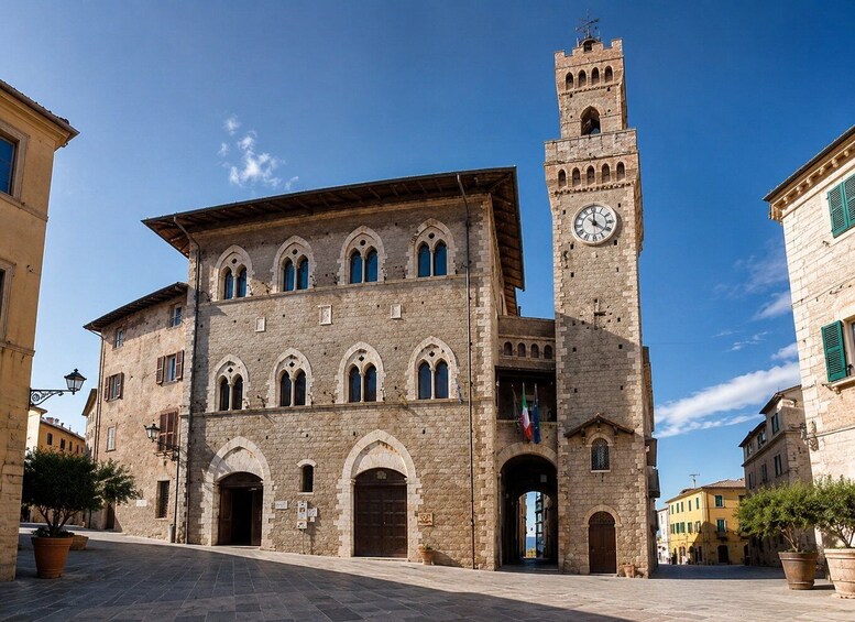 A historic building with a clock tower, arched windows, and a clear blue sky. 4