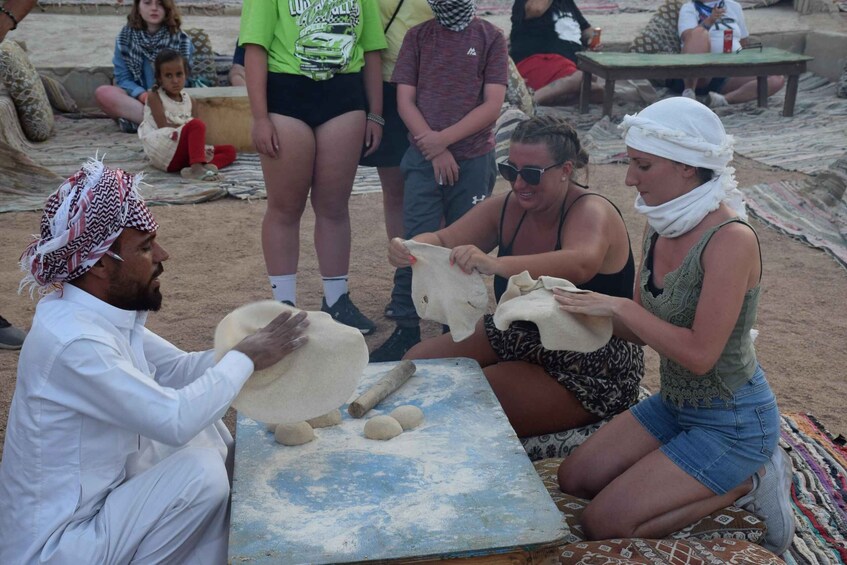 People kneeling on a mat, engaged in a dough preparation activity. 3