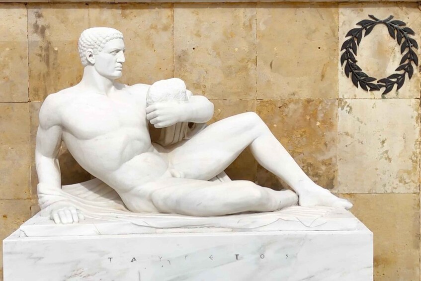 A marble statue of a reclining man with inscriptions on the base. 3