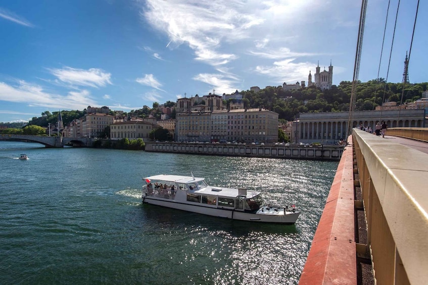 A river with a boat, a bridge, and buildings in the background. 2