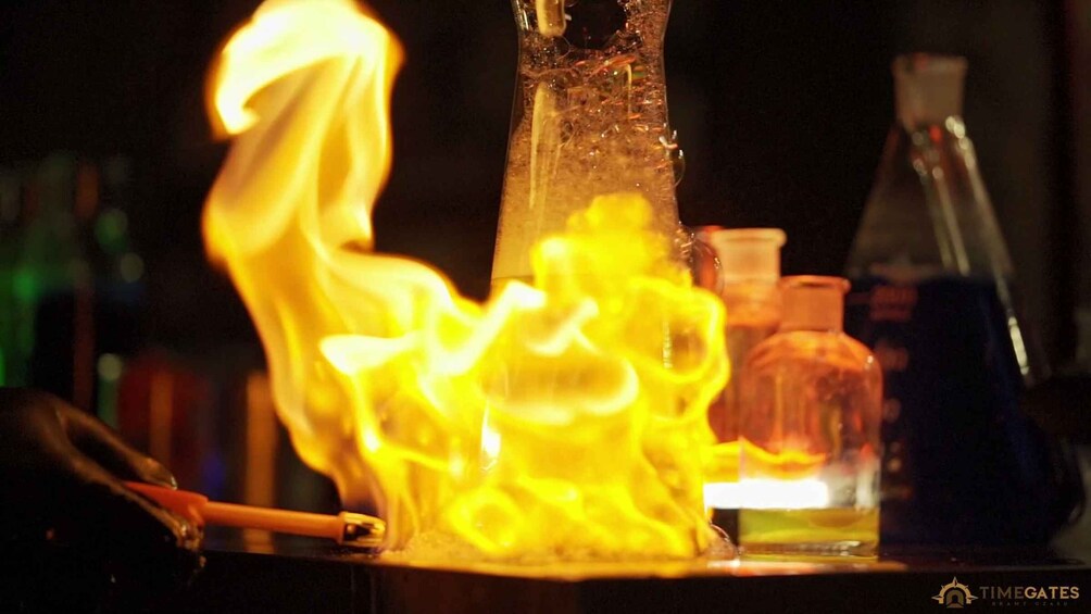 A laboratory setting with a Bunsen burner, flasks, and chemical bottles. 3