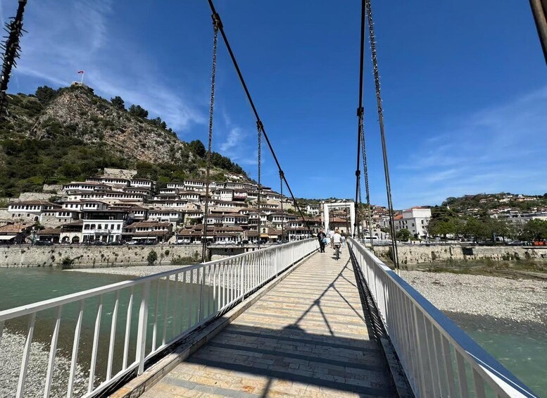 A suspension bridge over a river with a town on the opposite bank. 3