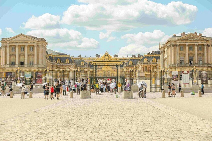 A historic building with classical architecture, a large open plaza, and a crowd of people. 3