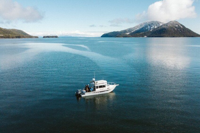 A boat on calm water with a mountain in the background. 1