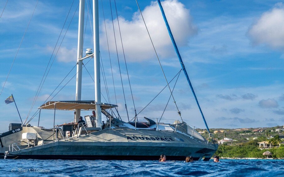 A sailboat named 'AQUASPACE' on the water with a clear sky and distant buildings. 3