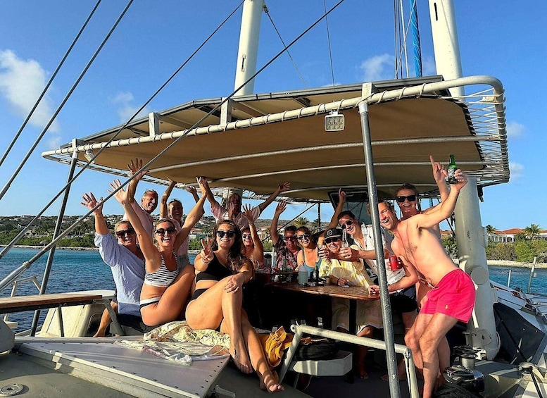 A group of people on a sailboat with a canopy, enjoying drinks and the seaside. 5
