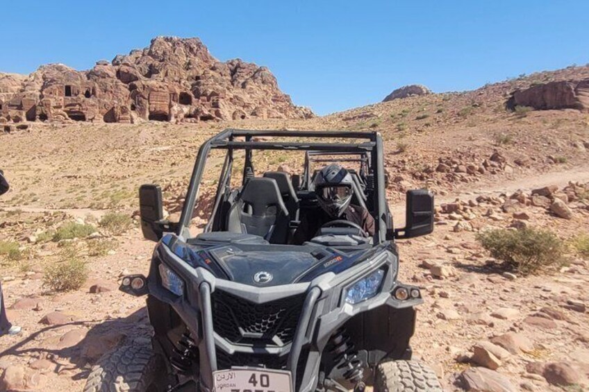A 4x4 vehicle in a desert with rocky terrain and a clear sky. 4