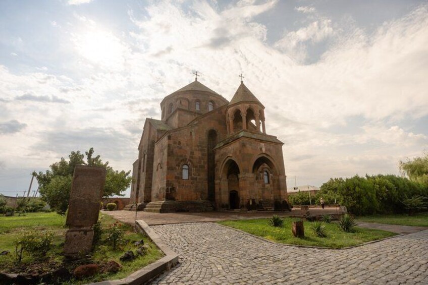 A historic church with a dome and bell tower, surrounded by a cobblestone path and greenery. 4