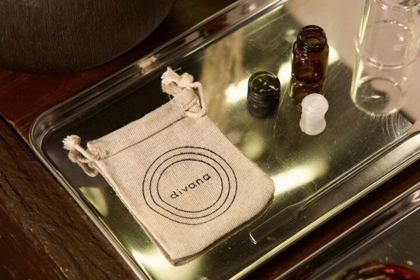 A tray with a cloth bag labeled 'divana,' a small bottle, and a glass. 4