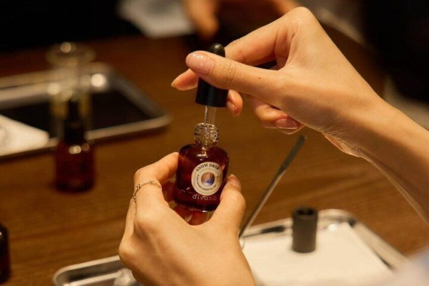 A person applying nail polish from a bottle. 1
