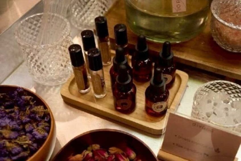 A display of small bottles, possibly containing essential oils, on a wooden tray. 2