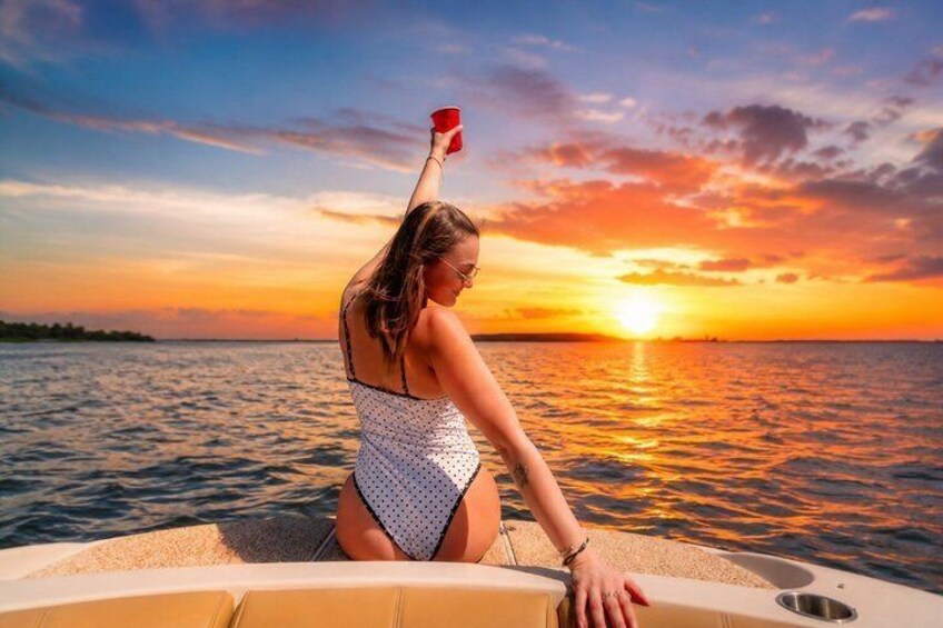 A person on a boat at sunset with a sunset in the background. 2