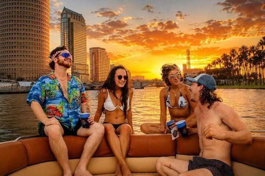 A sunset over a city skyline with a group of people on a boat. 3