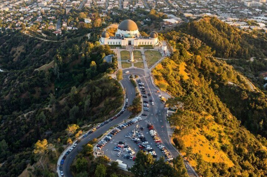 A dome-shaped building surrounded by a parking lot and roads on a hillside. 3