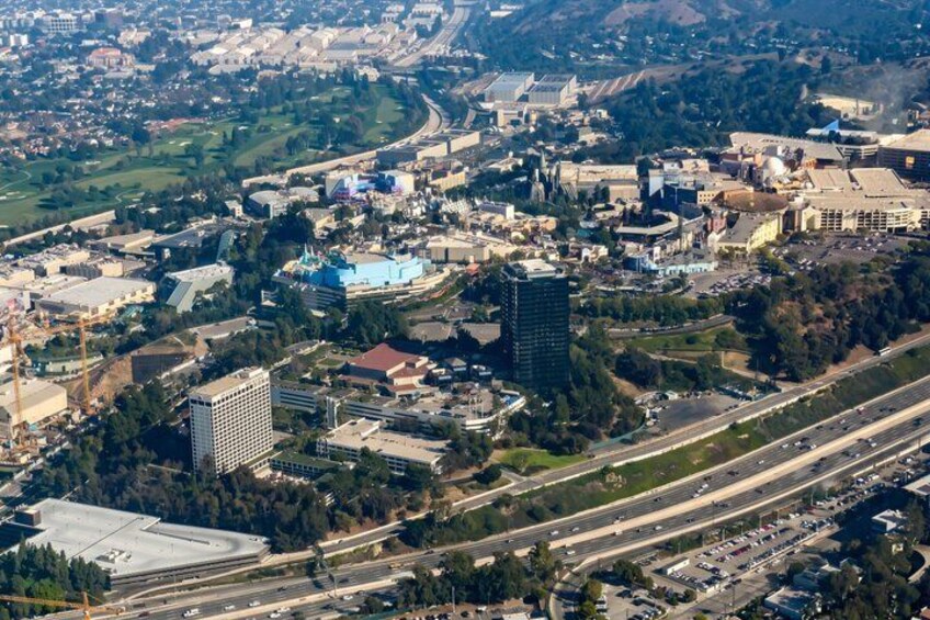 An aerial view of a city with a mix of commercial and residential buildings, a large blue-domed structure, and a highway. 2