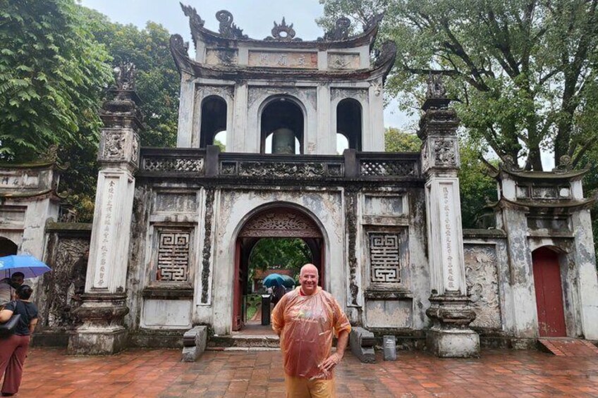 A traditional gate with intricate carvings and a red door, surrounded by trees. 5