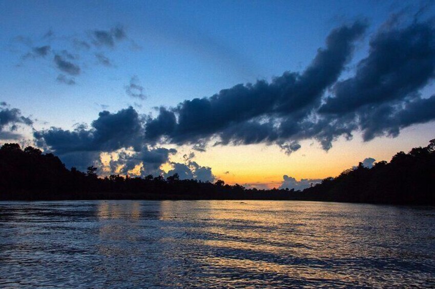 A river reflecting the sky at sunset with clouds and silhouetted trees. 2