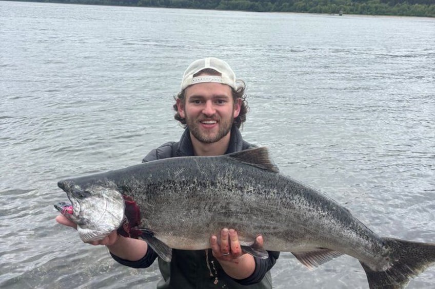A person holding a large fish in a body of water. 4