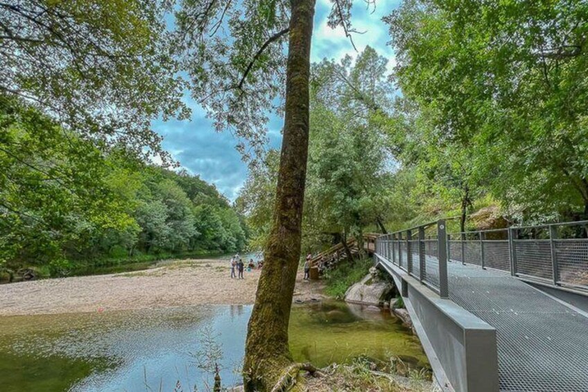 A riverbank with a wooden bridge and a metal walkway. 3