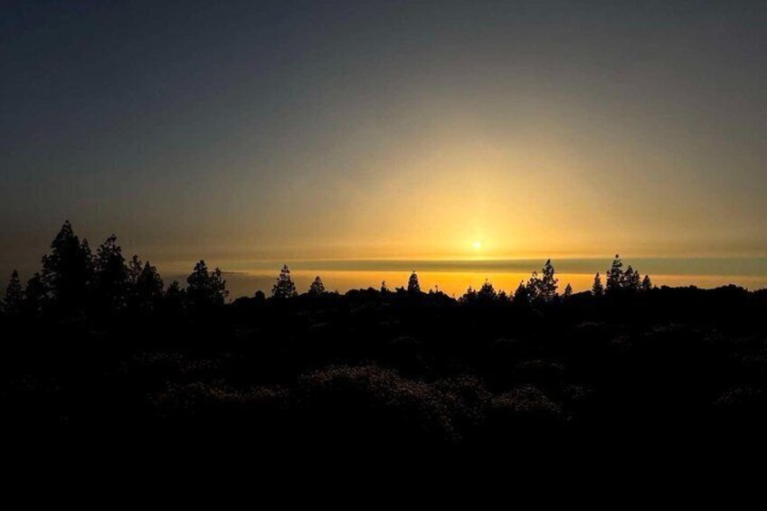 A sunset over a forested landscape. 4
