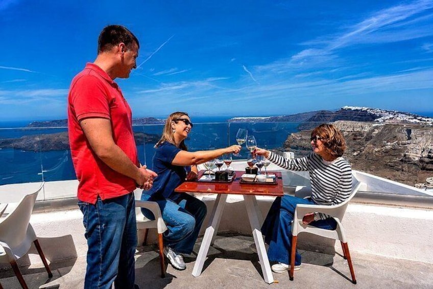 Three people at a table with a scenic view of a coastline and mountains. 1