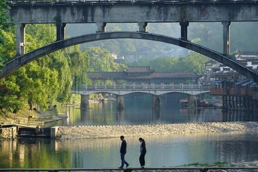 A bridge over a river with traditional buildings in the background. 1