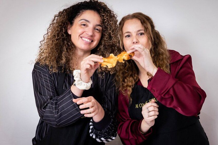 Two people holding a piece of food. 5