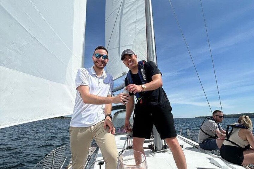 Two people on a sailboat with a clear sky and calm sea. 3