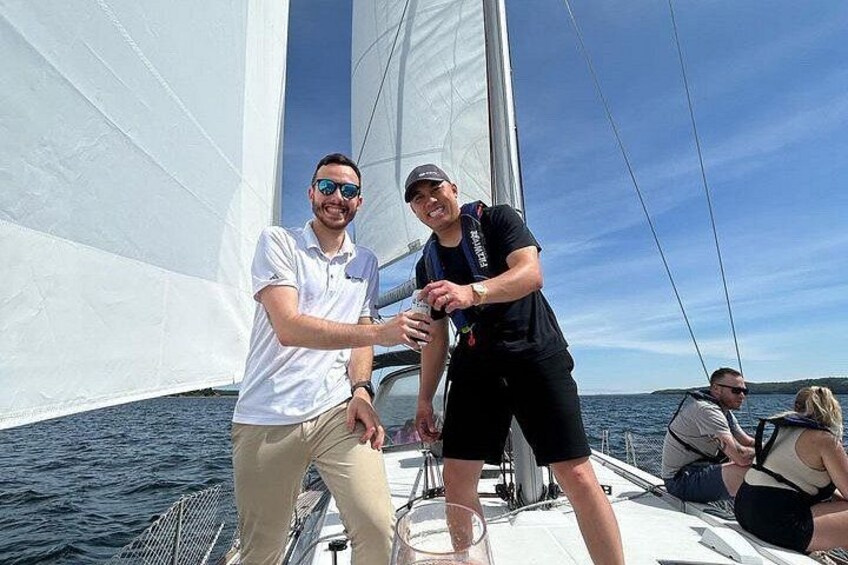 Two people on a sailboat with a clear sky and calm sea. 3