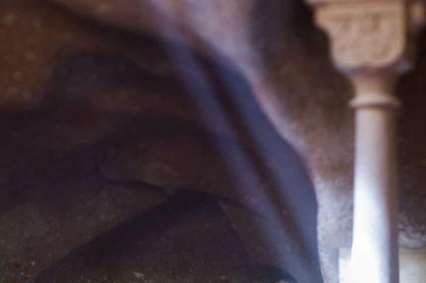 A close-up of a fabric with a dark color and a white column with a capital letter 'T' on it. 3