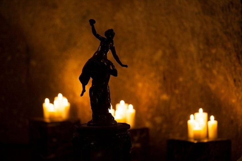 A statue of a woman holding a child, surrounded by candles. 5