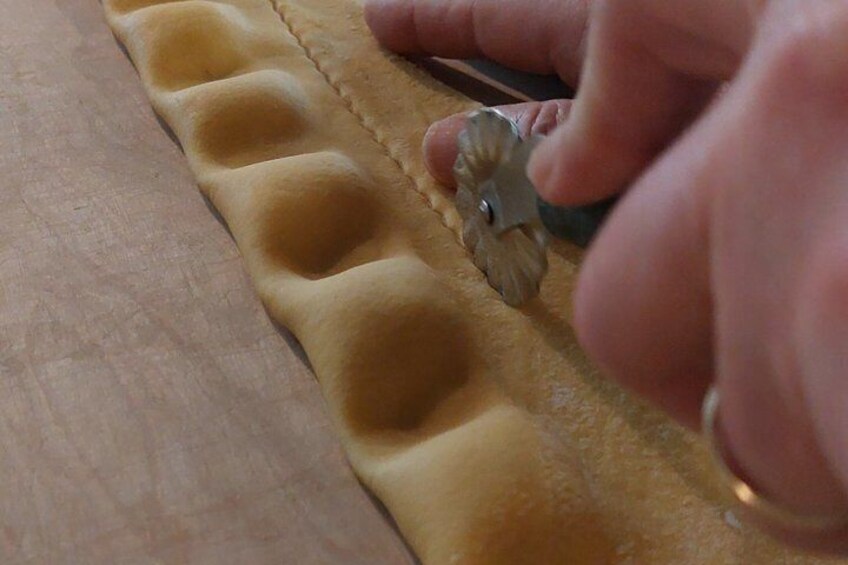 A hand using a cookie cutter on dough. 2